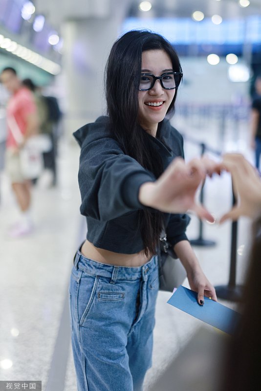 卢昱晓清早从机场出发 脸颊比心跟粉丝比爱心互动